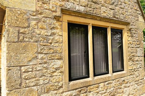 windows on a historic stone house porch with metal mullins|historic home window replacement covenant.